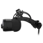 Black vr headset with padded ear cups and adjustable head strap, shown from a side view with a cable extending downward.