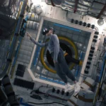 Person wearing a vr headset floats in zero gravity inside a space station module, reaching toward a wall amid panels and equipment.
