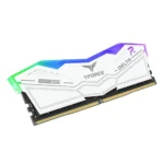 Ddr4 ram module with a white heatsink and multicolor rgb lighting (green/blue/purple) on a desktop pc side, gold connector pins visible.