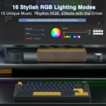 Monitor showing rgb lighting software interface with color wheel and sliders; blue download bar, keyboard with yellow accents on a desk with speakers nearby.