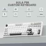 Aula f99 custom keyboard on a light desk, highlighting wireless bt/2. 4g, gasket structure, hot-swappable switches, rgb backlight, 8000mah battery, pbt keycaps, and 96% layout with numpad.