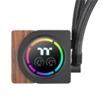 All-in-one cpu liquid cooler block with a circular rgb gauge showing two temperature readouts and braided hoses extending from the side, mounted on a wooden accent plate